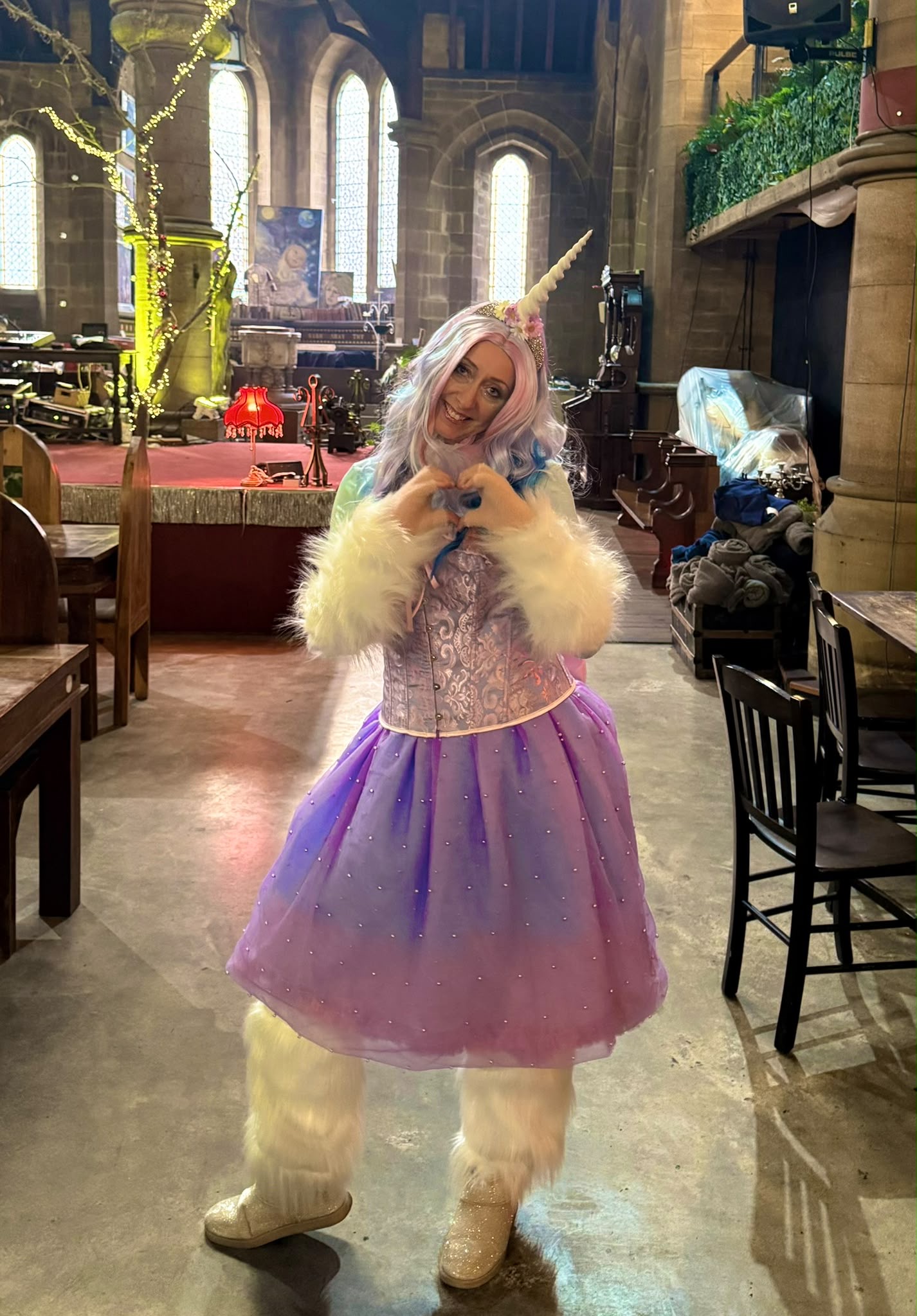 A giant rabbit character in a purple dress inside a decorated hall