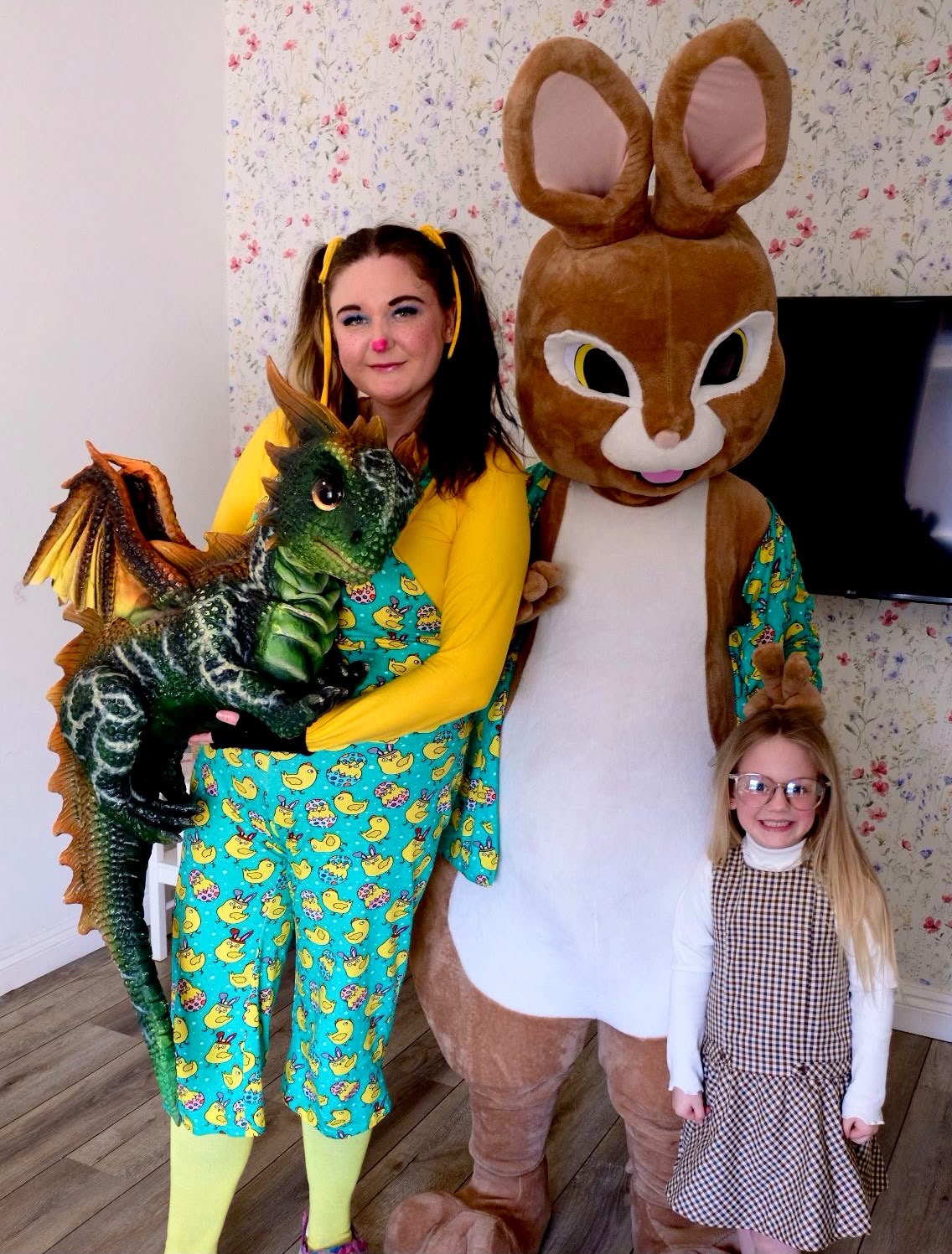 A party host with a green dragon, a giant rabbit character and a child