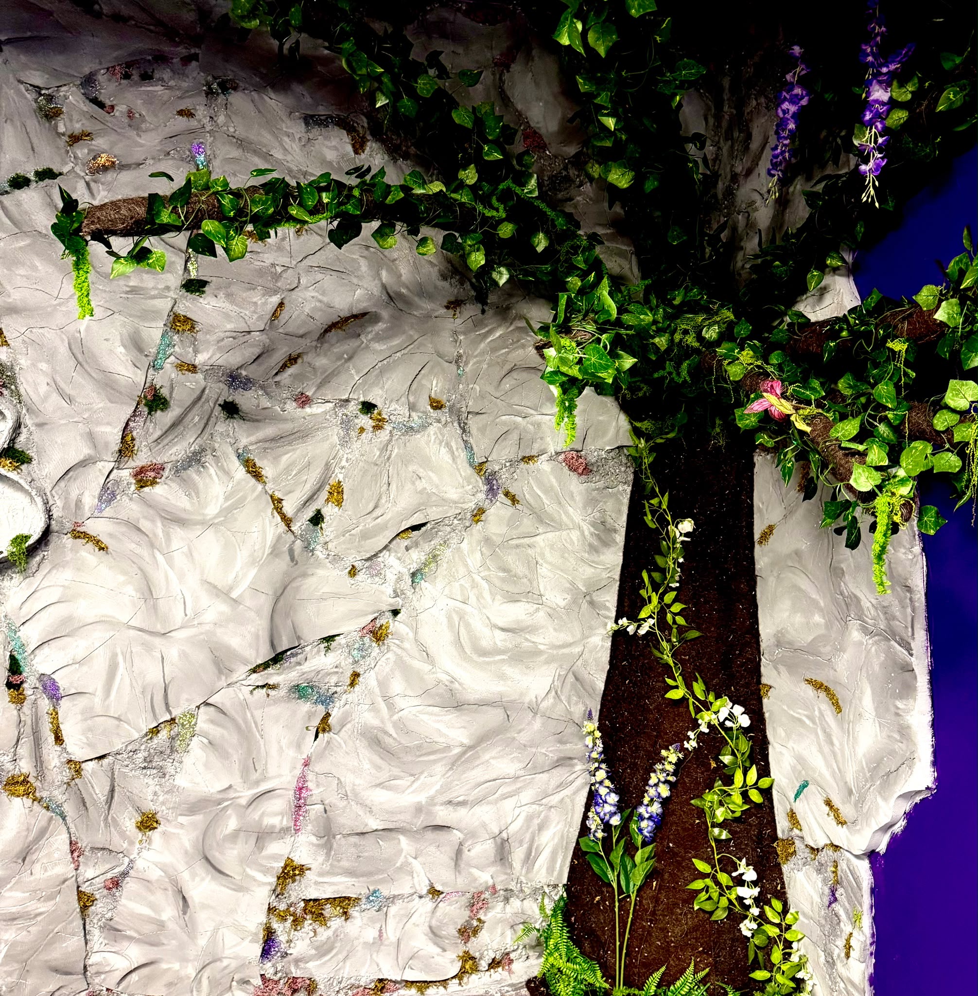 A decorative tree trunk and leafy canopy inside the fantasy venue