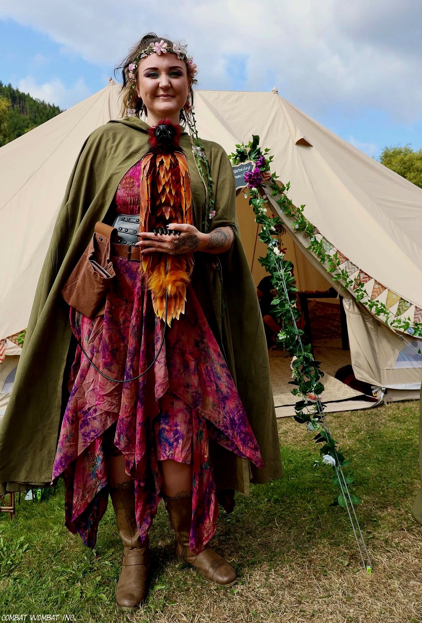 A cloaked woodland storyteller holding a lantern beside a bell tent
